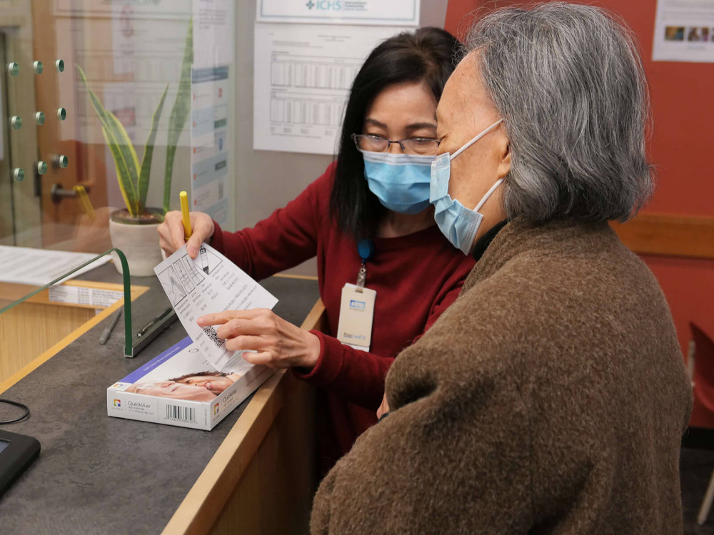 ICHS staff explaining COVID test kit in Cantonese