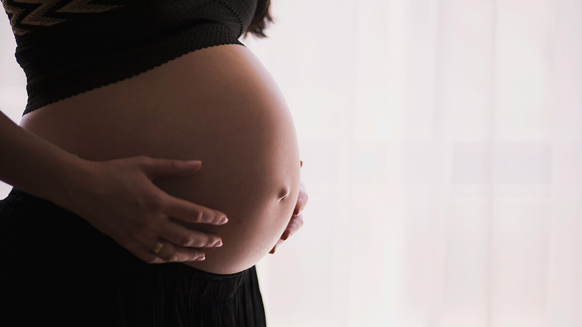 pregnant woman cradling her belly